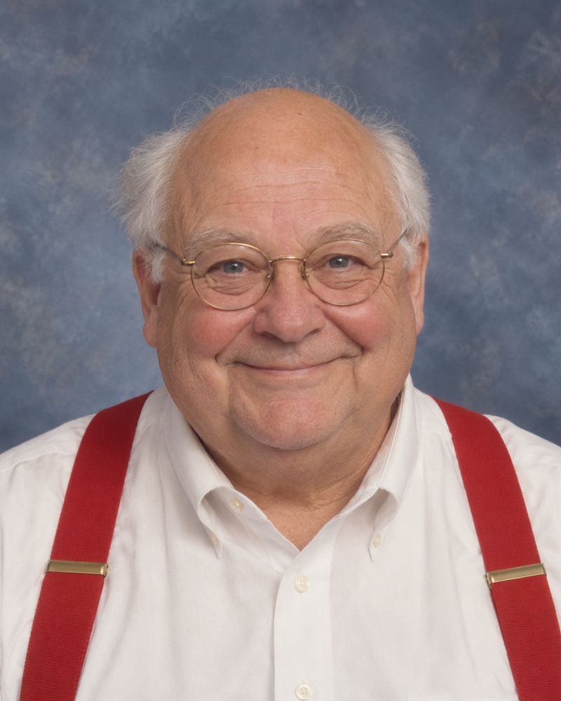 Portrait officiel du maire Everett Holloway, souriant, en chemise blanche et bretelles rouges